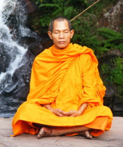 Thai Abbot meditating near waterfall