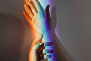 hands with rainbow light
