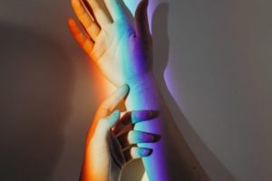 hands with rainbow light